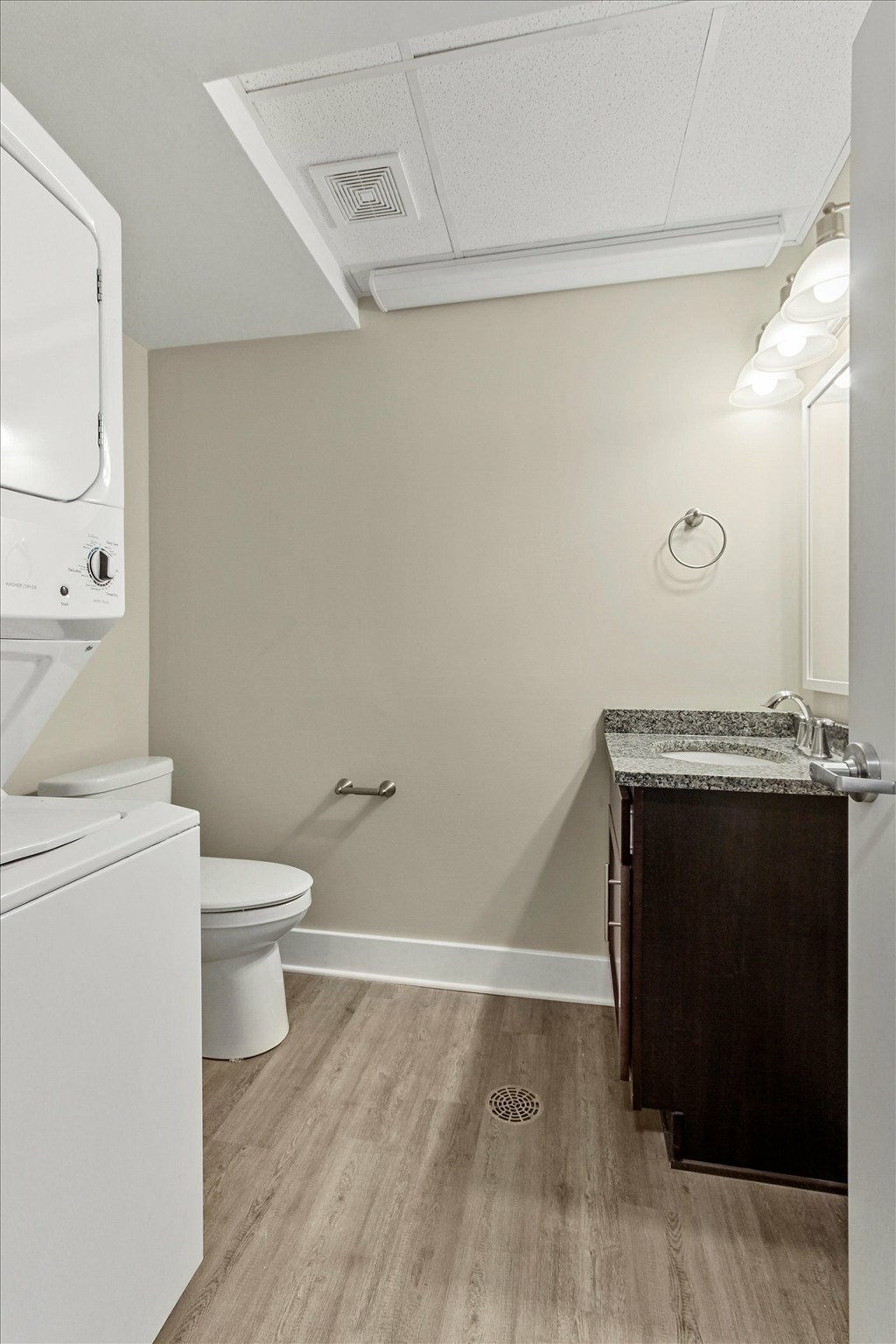 A small bathroom with a toilet, sink and a washer and dryer.
