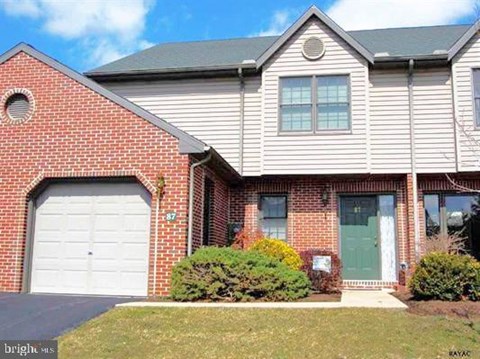A house with a garage door and a green door.