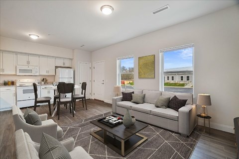 A well-lit living room with a grey sofa and a coffee table.
