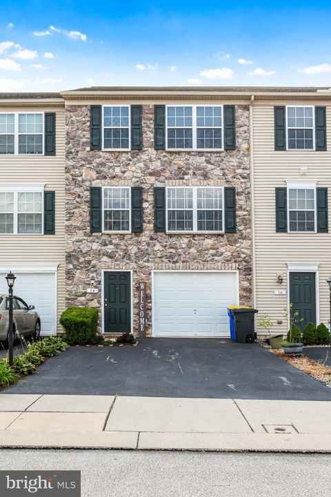 A two-story building with a stone facade and a garage door.