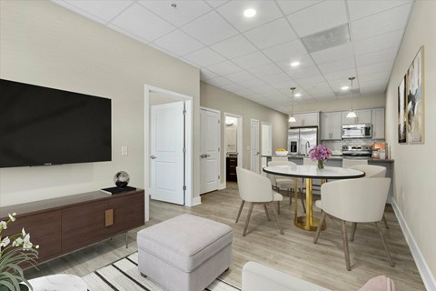 A modern living room with a flat screen TV, a white sofa, and a dining area with a table and chairs.