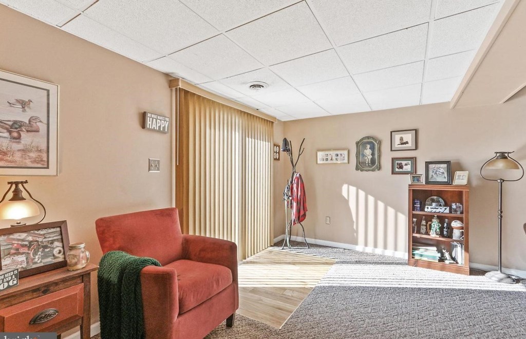 A living room with a red chair and a sign that says "HAPPY".