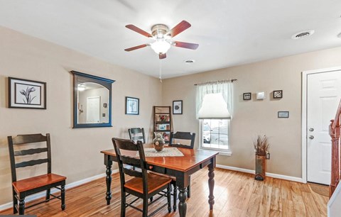 A dining room with a wooden table and chairs.