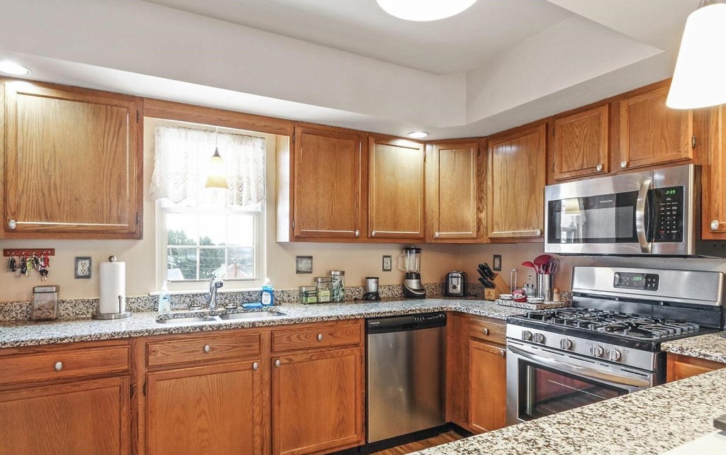 A kitchen with wooden cabinets and granite countertops.