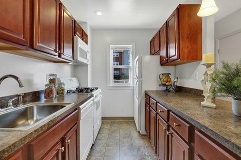 A kitchen with brown cabinets and a white refrigerator.