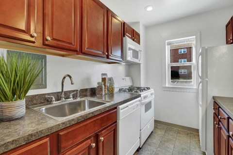 A kitchen with brown cabinets and a white fridge.