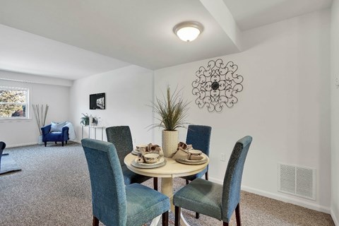 A dining room with a round table and chairs.