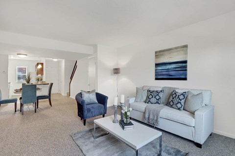 A living room with a grey couch, a blue armchair, and a coffee table.