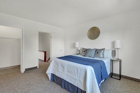 A bedroom with a bed, nightstand, and lamp.