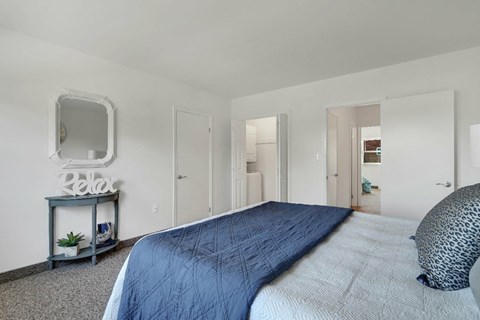 A bedroom with a large bed and a "relax" sign on a side table.