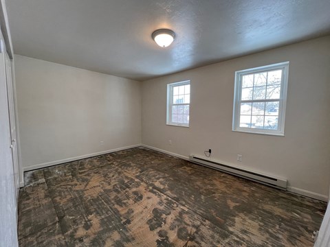 A room with a window and a floor that is being renovated.