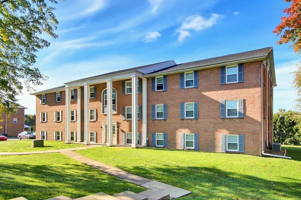 A large red brick building with a green lawn in front.