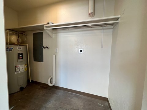 A white wall with a pipe and a door.