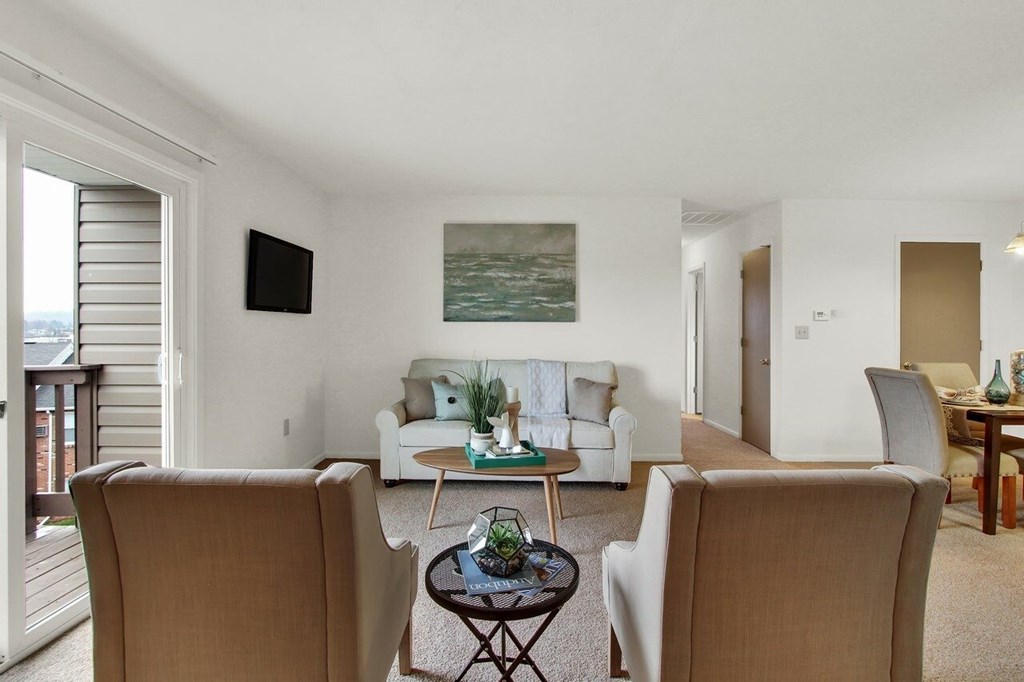 A living room with a couch, chairs, and a painting on the wall.