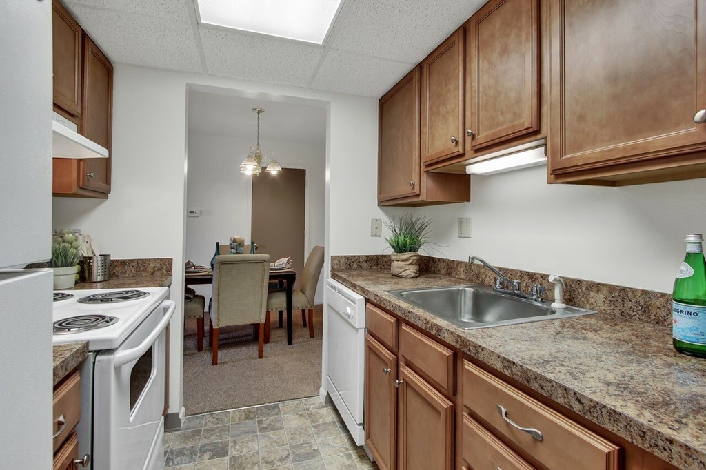A kitchen with brown cabinets and a white refrigerator.