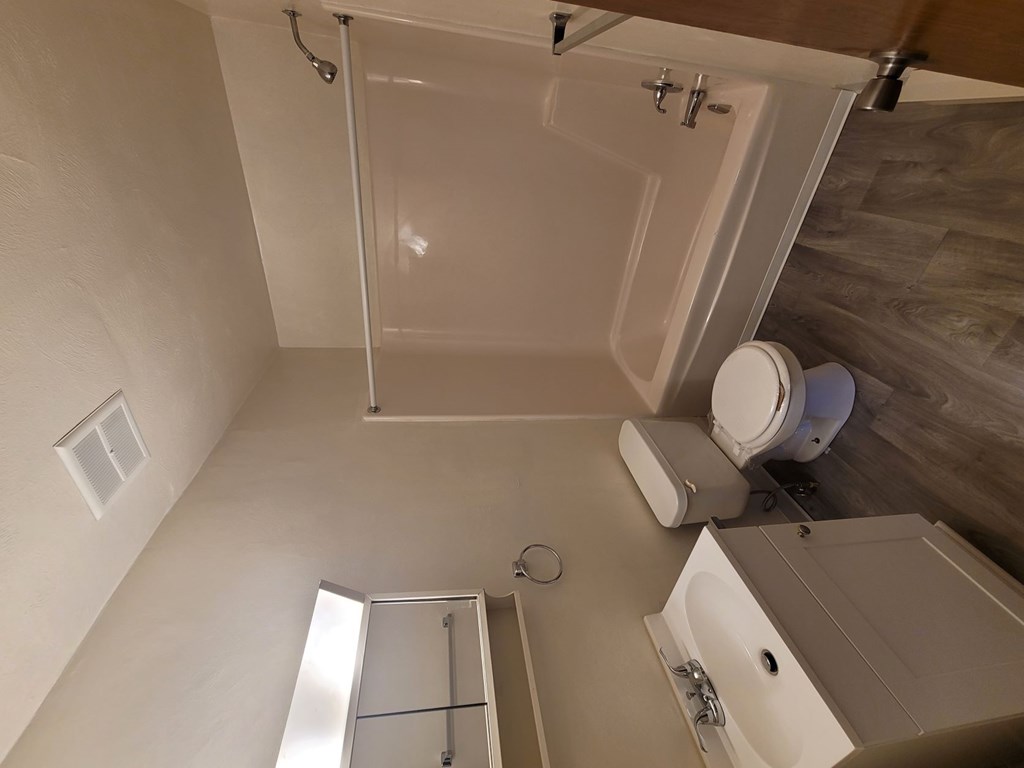 A white bathroom with a walk-in shower and a toilet.