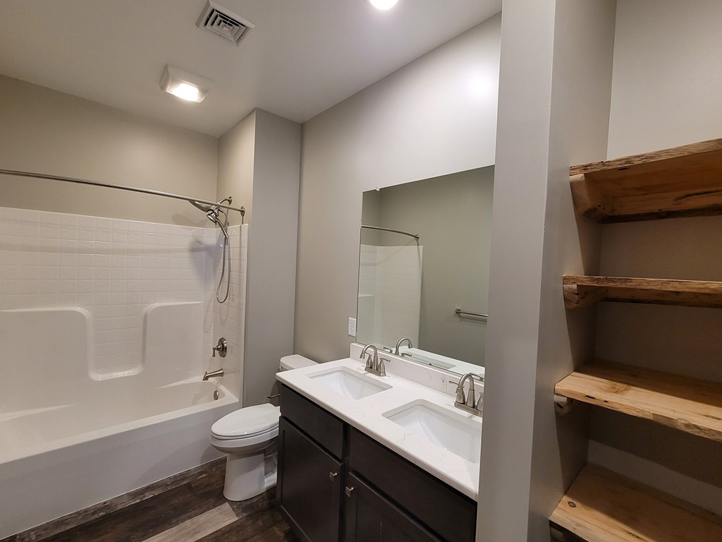 A bathroom with a white tub, sink, and toilet.