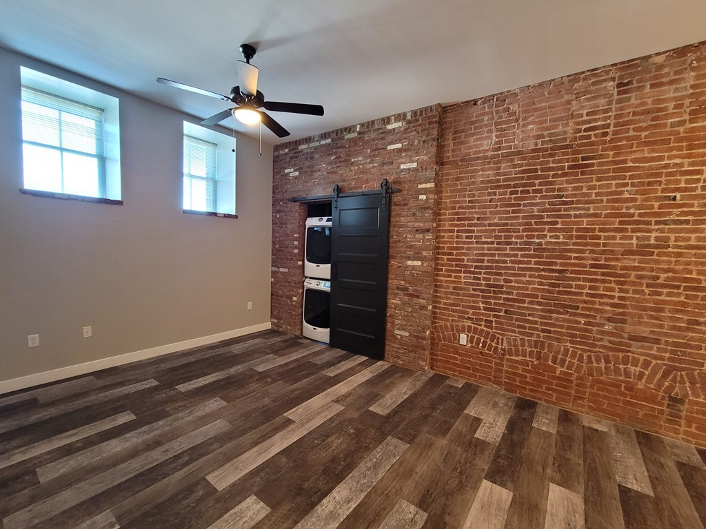 A room with a brick wall and wooden flooring.