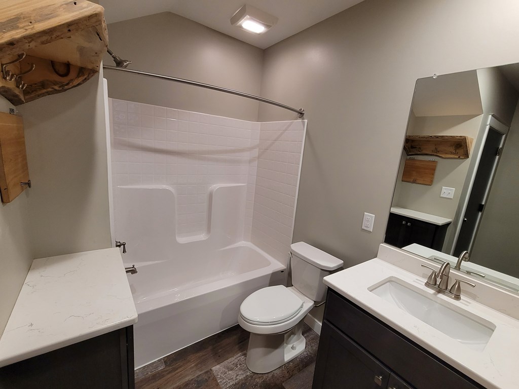 A bathroom with a toilet, sink, and shower.