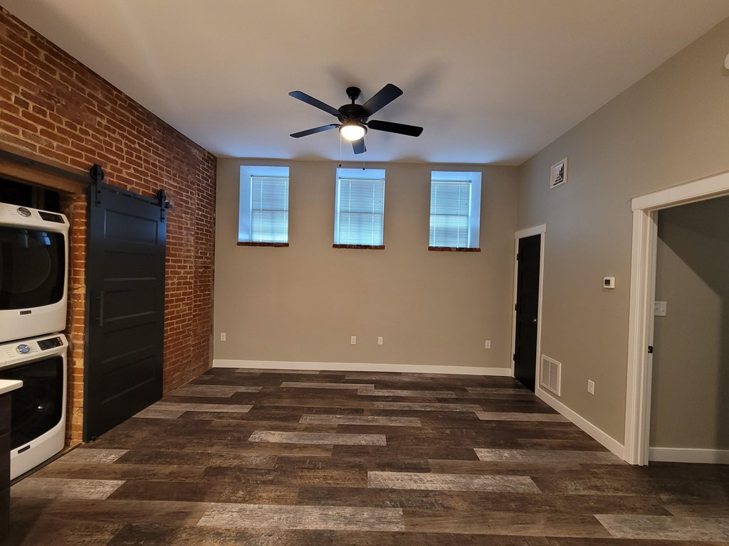 A room with a brick wall and a ceiling fan.