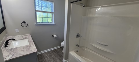 A white sink in a marble countertop in a bathroom.