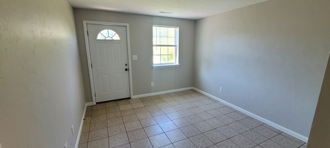 A room with a white door and a window.