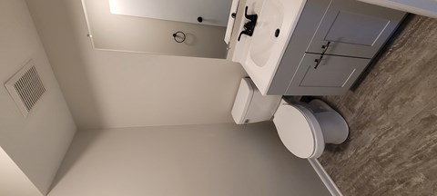 A white toilet is in a small bathroom.