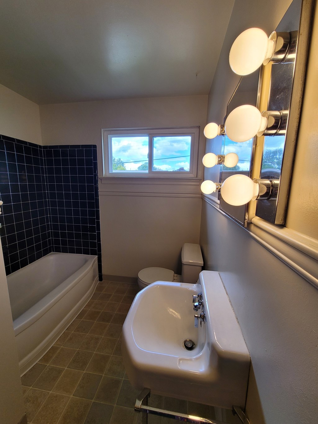 A bathroom with a white sink and a window.