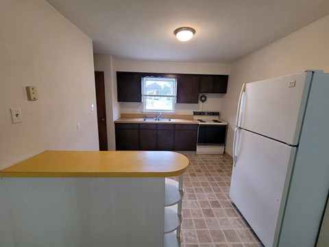 A kitchen with a white refrigerator and a wooden counter.