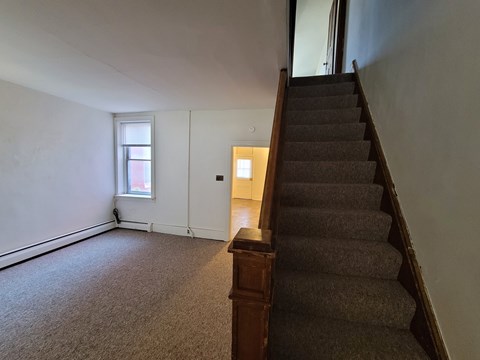 A staircase with a carpeted floor and wooden banister.
