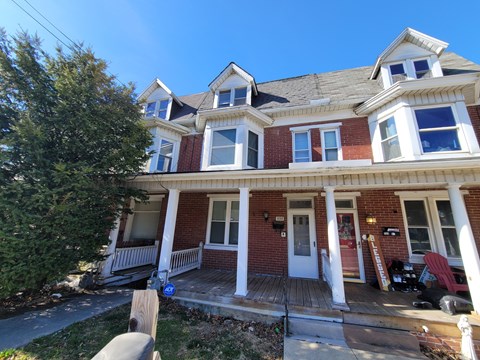 A red brick house with white trim and a white door.
