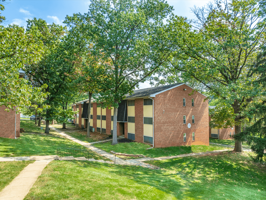 A red brick building with a black fence in front of it.