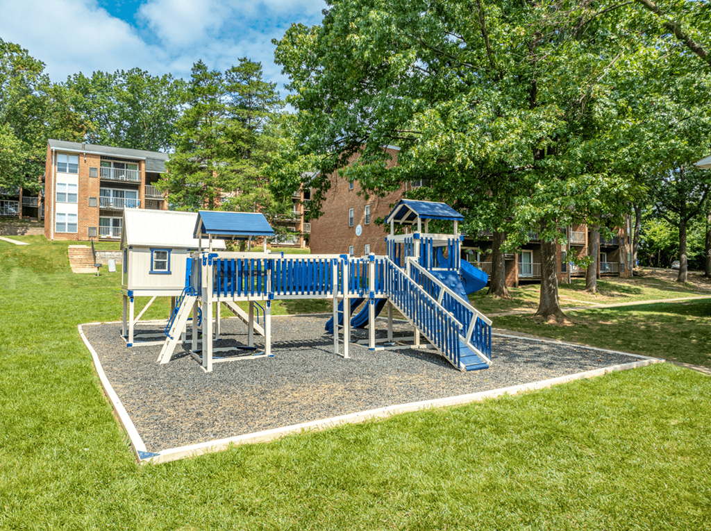 A playground with a blue slide and a white and blue structure.