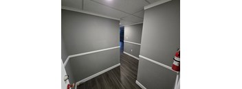 A hallway with a red fire extinguisher on the right side.