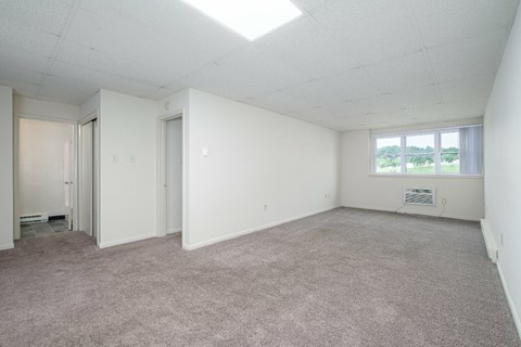 Empty room with carpeted floor and white walls.