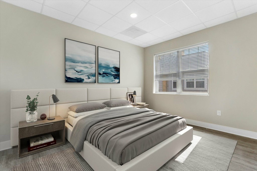 A bedroom with a large bed and two framed pictures on the wall.