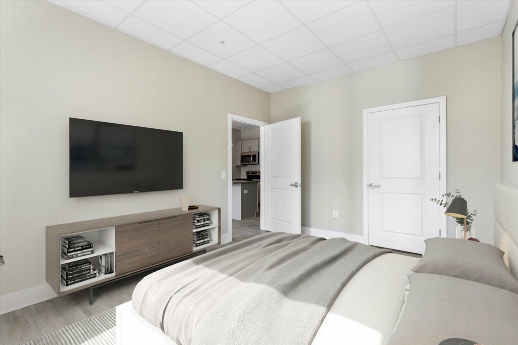 A bedroom with a bed, a television, and a cabinet.