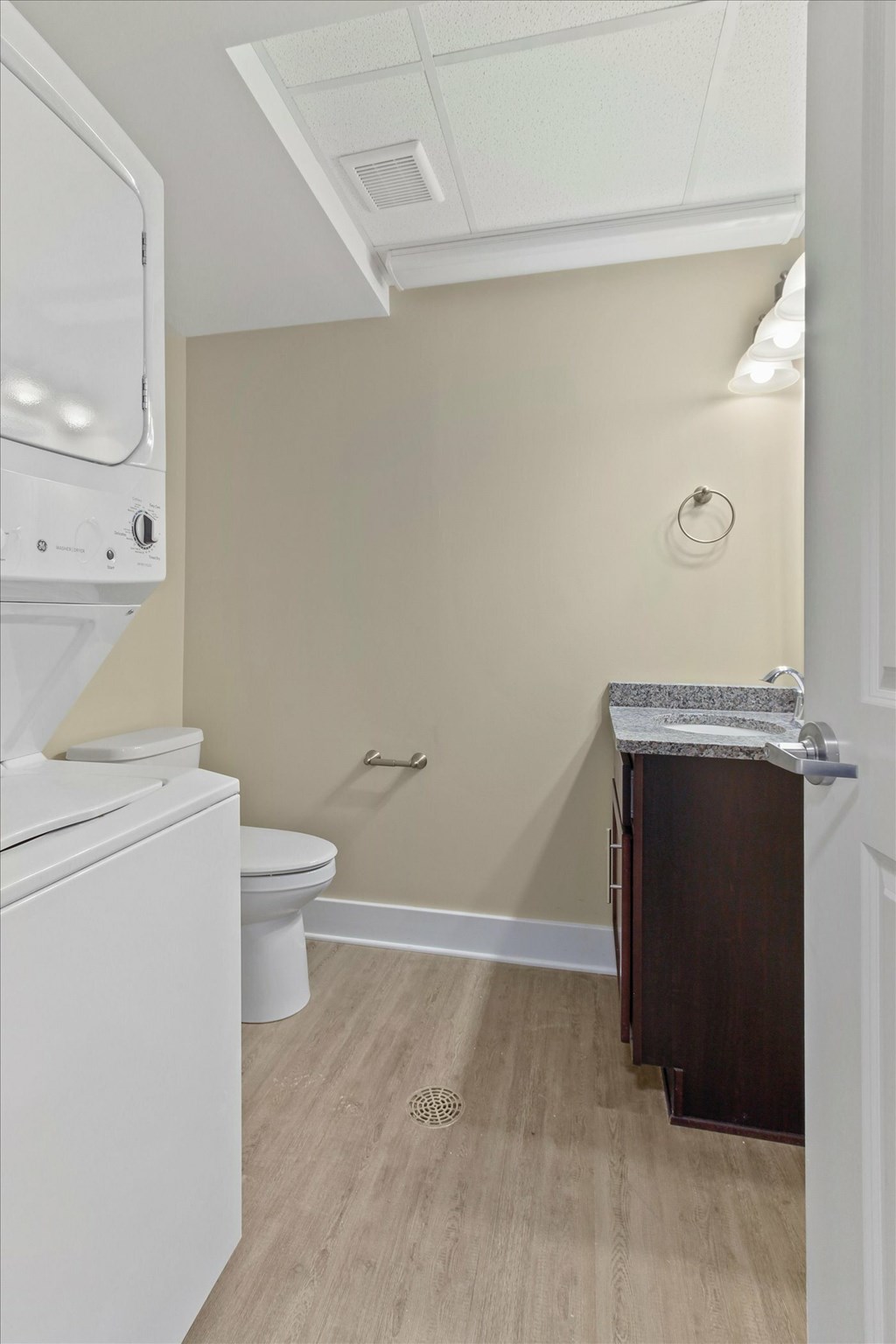 A small bathroom with a toilet, sink, and shower.