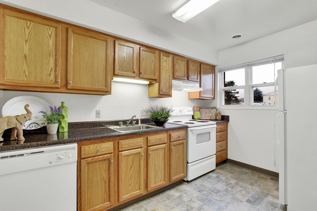 A kitchen with wooden cabinets and white appliances.