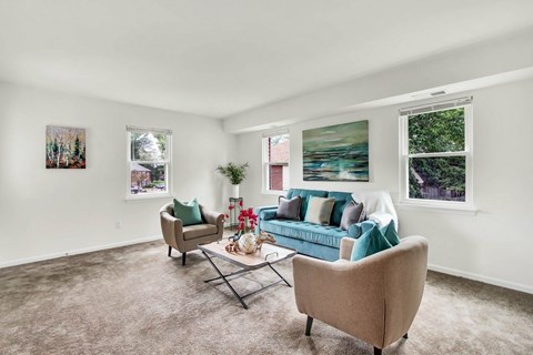 A living room with a couch, chair, and pictures on the wall.