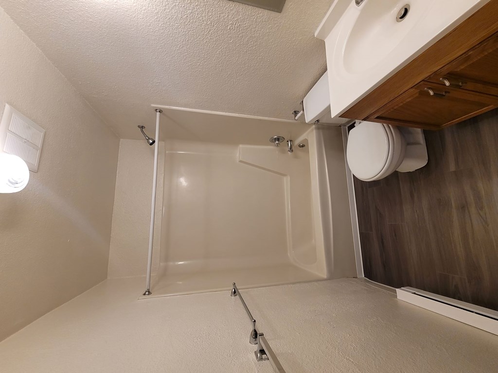 A white bathroom with a glass shower door.