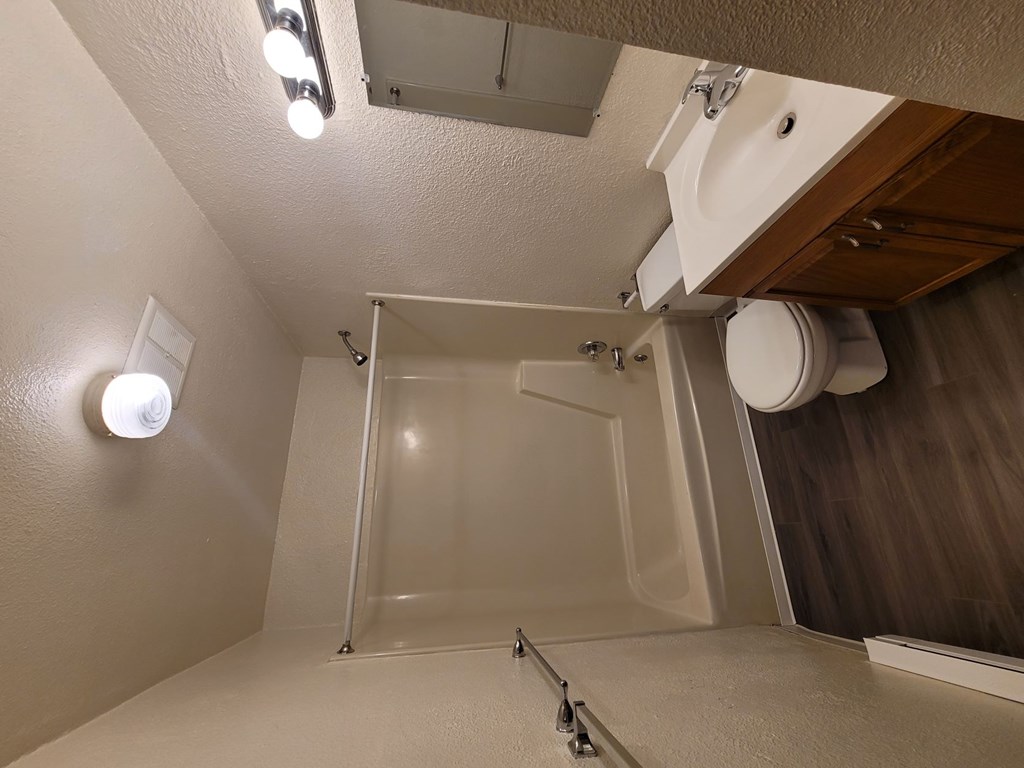 A white bathroom with a toilet, sink, and shower.