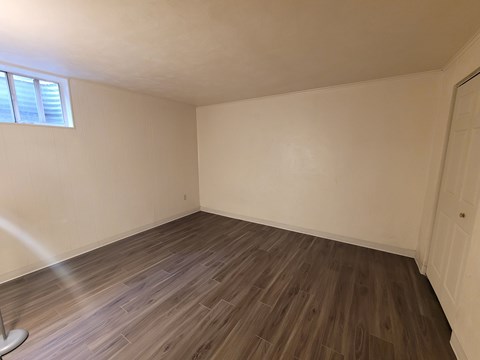 A room with wooden flooring and a window.