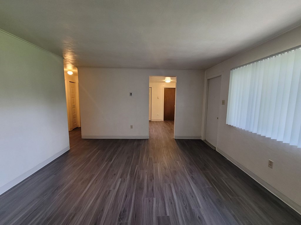 A room with wooden flooring and white walls.