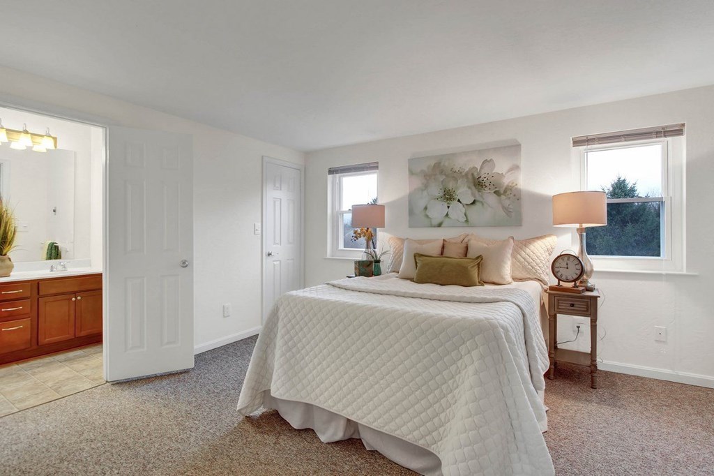 A bedroom with a large bed and a painting on the wall.