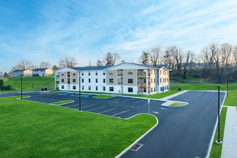 A large white building with a parking lot in front of it.