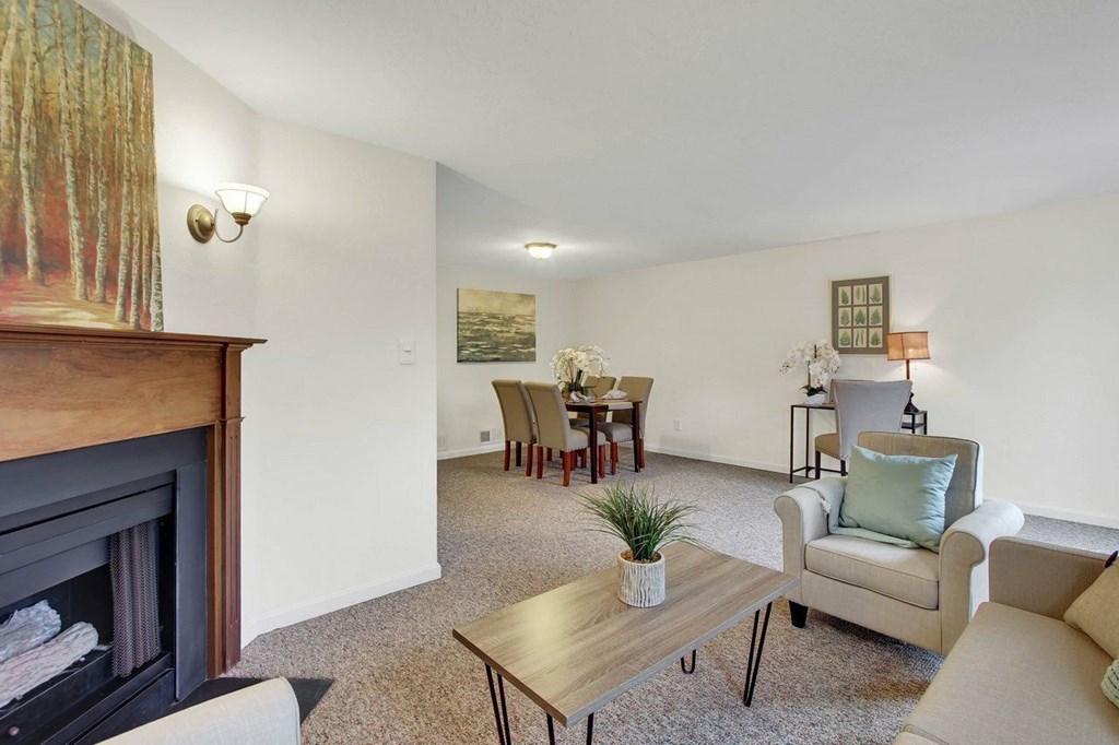 A living room with a fireplace and a painting on the wall.