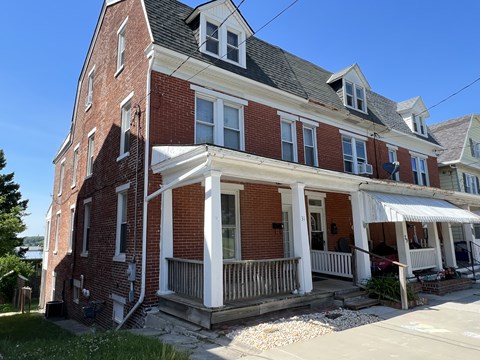 A red brick house with a white porch.