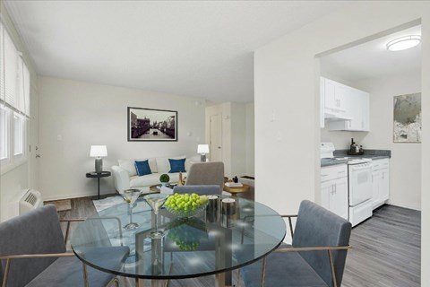 A modern dining room with a glass table and chairs.