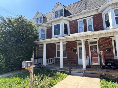 A red brick house with a mailbox in front.
